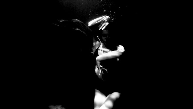 beautiful girl dancing underwater in black and white contrast video