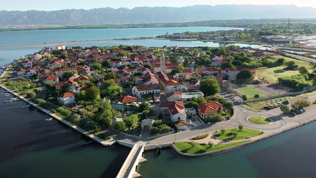 Nin, Croatia - 4K Flying around of the historic town and small island of Nin with traditional salt still fields and blue Adriatic sea on a sunny summer morning in Dalmatia region of Croatia