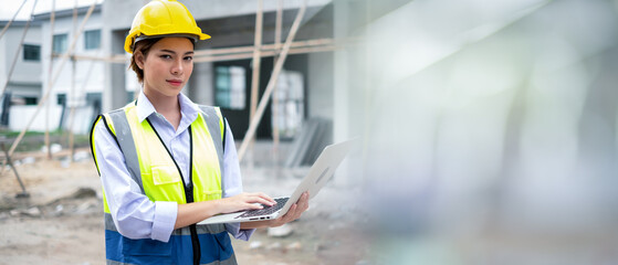Woman Worker in a construction site. Female Architecture engineering holding a laptop on building...
