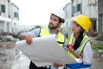 Engineers on building site. Engineer are working contruction on site plans to build high-rise buildings building. Architect caucasian man working with colleagues mixed race in the construction site.