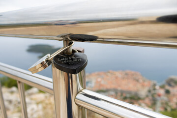 Love locks lockend onto a railing on the Dubrava Observation Point on the mountain looking down at the old town of Dubrovnik, Dalmatia, Croatia.