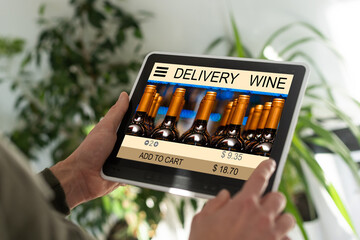 Person holding tablet and buying wine online.