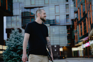 smiling man on the background of the business center with a laptop in his hands