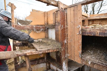 Workers disassemble and demolish an old wooden hut by hand