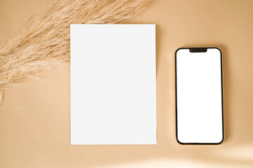 Mockup card and phone with dry grass on beige background
