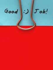 Blue note card with text written GOOD JOB clip with red paper for copy space - Concept of praising...