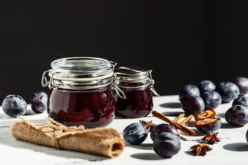 plum and prune fruit jam with spices on a white wooden background, the concept of canning at home