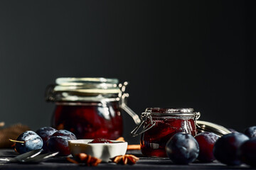 plum prune fruit jam with spices on a dark wooden background, the concept of preservation at home