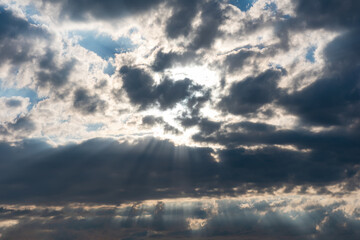 Fototapeta na wymiar Sky background. Bright sunlight trough dark clouds. Copy space. Epic heaven