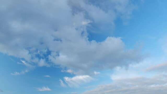 Cloud nature background. Blue sky with cirrus clouds and sun. Nature background of airy cloudscape. Timelapse.