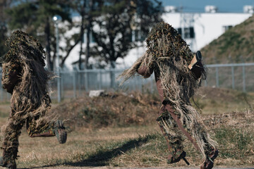 ギリースーツを着た狙撃手（sniper in ghillie suit with presicion rifle）