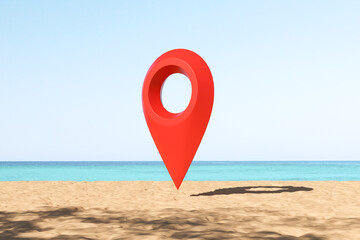Big red geo tag at the sand beach, sea view