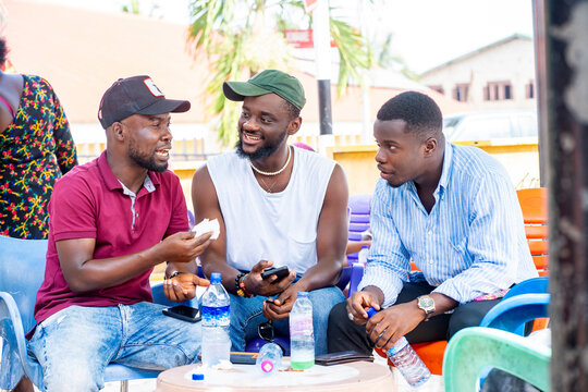 candid image of african guys seated, having conversation outside-communication concept