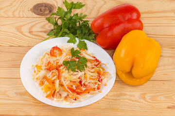 Salad with chopped white cabbage and bell pepper on table