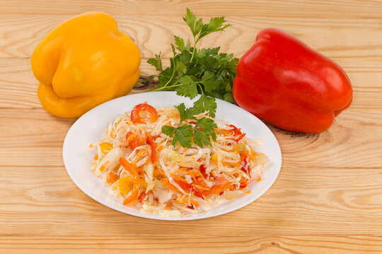Salad with chopped white cabbage and bell peppers on table