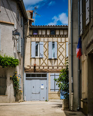 Fototapeta na wymiar Half timbered house and light blue shutters in the medieval village of Fanjeaux, in the south of France (Aude)