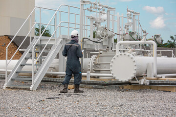 Male worker inspection at steel long pipes and pipe elbow in station oil factory during refinery valve of visual check record pipeline
