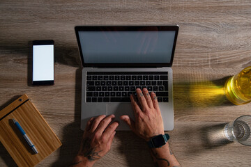 Overhead view of businessman using laptop computer and smart phone at office desk