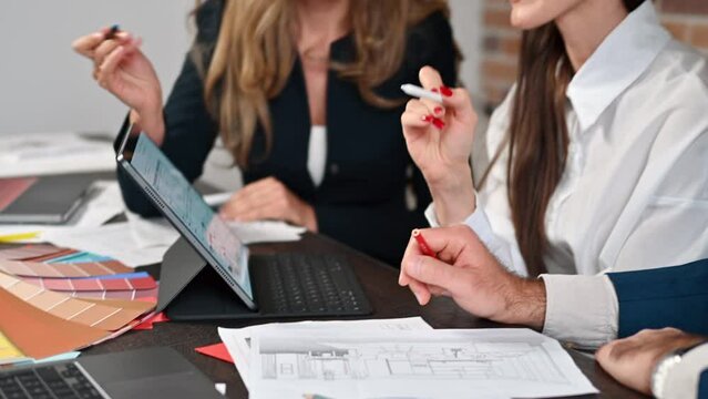 Business designers working with chars and colored blueprints at the office