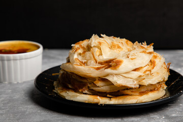 Parotta : an Indian bread made with refined flour which is cooked to flaky crispness and served...