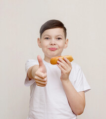 Hot dogs are my favorite. A cute little boy eating a hot dog while outdoors.