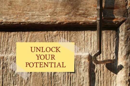 Old wood locked door with text  UNLOCK YOUR POTENTIAL ,concept of unfold unleash talents, to remind someone they capable to do more, just think less act more and take action to put dreams into reality
