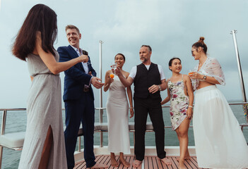 Group of friends party on yacht. Happy friends drinking cocktails and having fun in cruise ship...