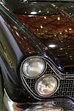 Detail of front mask, massive grille and typical twin round headlights of Lincon Continental Mark V, luxury limousine from 1960, brown metallic colour, as displayed on car expo in Nitra, Slovakia.