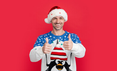 new year mood. happy man isolated on red background wear new year sweater. man in new year santa hat