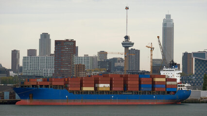 Rotterdam, Netherlands - Container ship loaded with containers and the downtown of Rotterdam in the background © I am from Mykolayiv