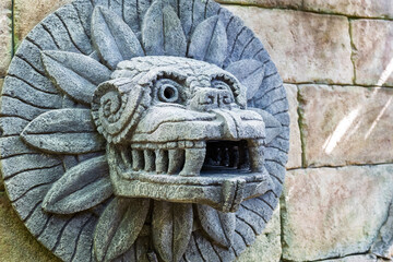 close-up of a dragon's head on the wall, stone sculpture in the Aztec style