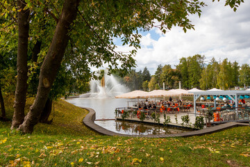 Rest in the park on a warm autumn day. Fountain Golden Ear on the Kamenka River among autumn trees, VDNKh, Moscow