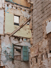 Wall and window of a destroyed house. Construction site, demolition, partial vie
