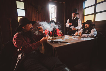 Cowboys group playing poker and card  gambler game in old American west saloon is cowboy vintage...