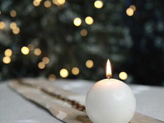 Festzeit - festlich gedeckter Tisch mit einer Kerze im Hintergrund ein geschmückter Weihnachtsbaum