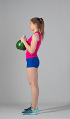 Training with kettlebells, a young athlete performs exercises with kettlebells, kettlebell lifting for the tone of the whole body