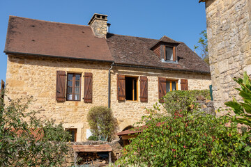 Fototapeta na wymiar traditional stone built french dwelling with wooden window shutters