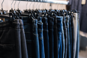 Rack with jeans in a clothing store. Different jeans on a hunger