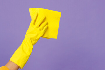 Close up cropped female hold in hand in rubber gloves microfiber cloth tidy up isolated on pastel...