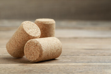 Corks of wine bottles on wooden table, closeup. Space for text