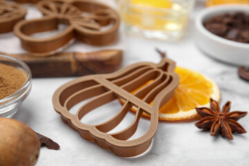 Cookie cutters of different shapes and ingredients on white marble table