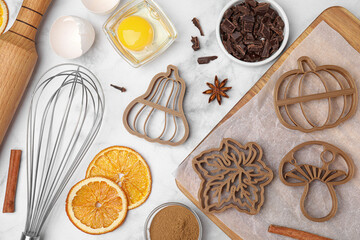 Flat lay composition with cookie cutters and ingredients on white marble table