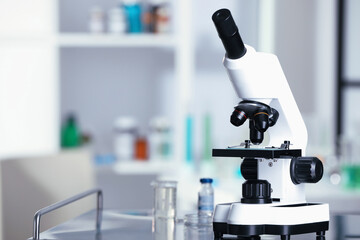 Modern medical microscope on metal table in laboratory, space for text