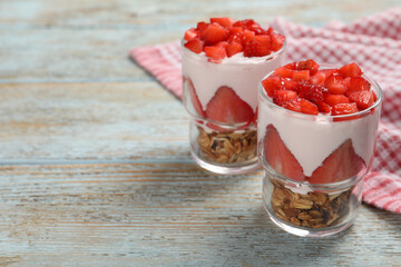 Glasses with delicious yogurt and strawberries on old wooden table, closeup. Space for text