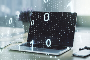 Double exposure of creative abstract binary code hologram on laptop background. Database and programming concept