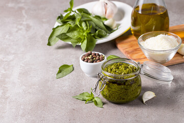 Basil pesto sauce in a jar. Ingredients for cooking, cheese, parmesan, garlic, olive oil. 