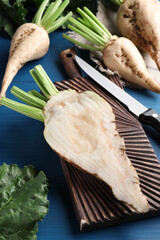 Whole and cut sugar beets on blue wooden table