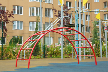Red curved ladder on outdoor playground in residential area