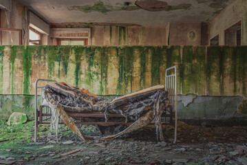 Very old and broken bed in a boarding school