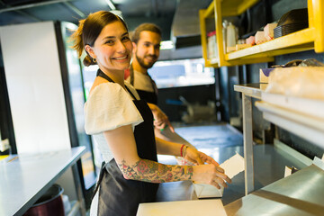 Attractive woman cook looking happy to work at the food truck